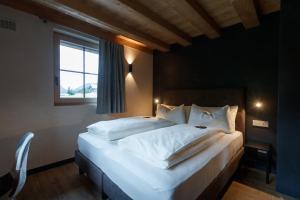 a bedroom with a large white bed with a window at Sun Villa Genf Spa - Relax in Livigno