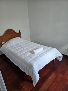 a bed with a white comforter in a room at Residencias Requinte T3 Espacoso com Terraco e Vista in São Roque do Pico +7 photos