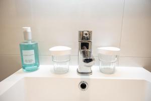a bathroom sink with a bottle of soap and two glasses at Gleeson's Roscommon in Roscommon +76 photos