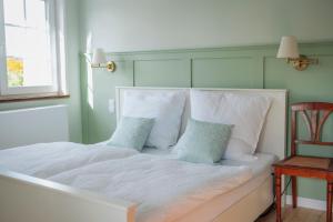 a bedroom with a white bed with pillows and a window at Villa Sand in Bad Emstal