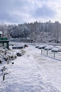 a parking lot covered in snow with cars parked at Willa Deptak in Krynica Zdrój