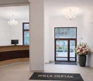 a lobby with a door and a potted plant at Willa Deptak in Krynica Zdrój