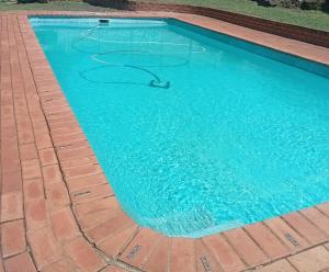 a swimming pool with a hose in the water at Maselli Guesthouse in Howick