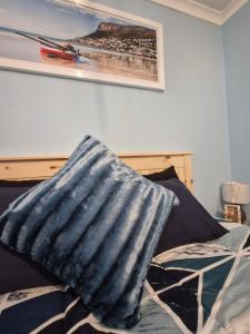a bed with a blue pillow on top of it at 77 on First! in Fish Hoek