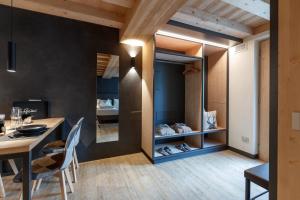 a room with a table and chairs and a dining room at Wind Villa Genf Spa - Relax in Livigno