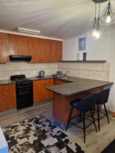 a kitchen with wooden cabinets and a black stove top oven at 77 on First! in Fish Hoek
