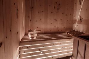 a sauna with a bucket in a wooden wall at Wind Villa Genf Spa - Relax in Livigno +27 photos