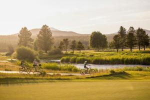 two people riding bikes along a river at 74 Meadow House in Sunriver