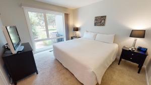 a bedroom with a bed and a tv and a window at 74 Meadow House in Sunriver