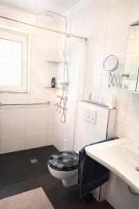 a bathroom with a black and white toilet and a sink at Ruhe Oase mit Gartenblick in Büren