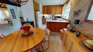 a kitchen with a wooden table with a vase of flowers on it at 74 Meadow House in Sunriver