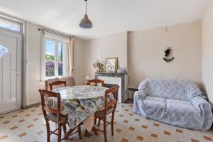 a dining room with a table and a couch at Gîte Le Trotteur in Monteaux