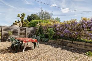 a table and chairs in a garden with purple flowers at Gîte Le Trotteur in Monteaux