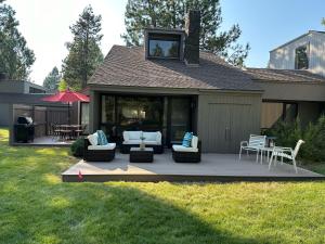 a backyard patio with couches and a table and chairs at 79 Meadow House in Sunriver