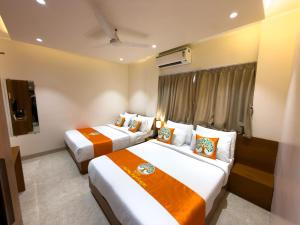 a hotel room with two beds and a window at Hotel Neem Heritage in Shirdi +39 photos