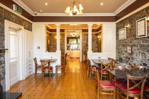 a dining room with tables and chairs and a stone wall at Gleeson's Roscommon in Roscommon