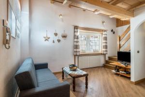 a living room with a couch and a tv at Appartamento Cinzia in Moena