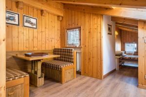 a room with wooden walls and a table and chairs at Appartamento Cinzia in Moena