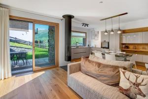 a living room with a couch and a kitchen at Spark Chalet e Spa Livigno in Livigno