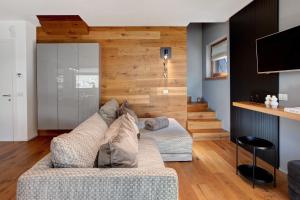 a living room with a couch and wooden walls at Spark Chalet e Spa Livigno in Livigno