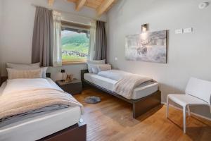 a bedroom with two beds and a window at Spark Chalet e Spa Livigno in Livigno