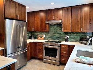 a kitchen with wooden cabinets and a stainless steel refrigerator at 73 Meadow House in Sunriver