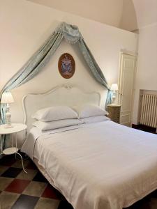 a bedroom with a white bed with a blue canopy at Masseria Rienzo in Ostuni