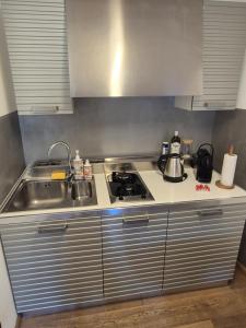 a small kitchen with a stove and a sink at Urban Loft Duomo in Alba