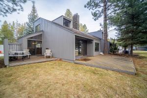 a home with a large backyard with a wooden deck at 76 Meadow House in Sunriver