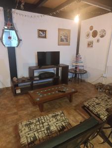 a living room with a table and a tv at Casa Hebe - En las sierras de Córdoba - cuenta con tres habitaciones y capacidad para 8 personas, tranquila con increibles vistas in Villa Parque Siquiman