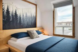 a bedroom with a bed with a large painting on the wall at Le Wolfe - 2 Bedrooms - 2 min Falls - Free Parking in Boischâtel