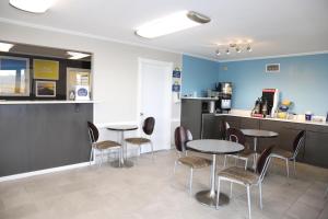 a waiting room with tables and chairs and a counter at Days Inn by Wyndham Monroe, Louisiana in Monroe