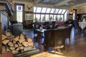 a restaurant with chairs and a table and a fireplace at BEST WESTERN The Crianlarich Hotel in Crianlarich