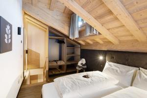 a bedroom with two beds and a wooden ceiling at Chalet River Villa Genf Spa - Relax in Livigno
