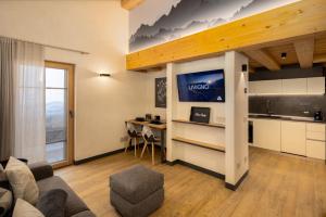 a living room with a couch and a tv and a table at Chalet River Villa Genf Spa - Relax in Livigno