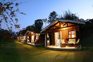 a row of log cabins at night with lights at Chalé Primavera in Juquitiba