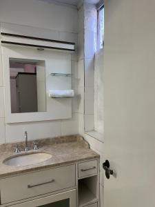 a bathroom with a sink and a mirror at Pousada Centro in Gramado +59 photos