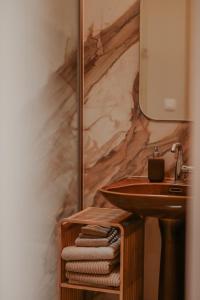 a bathroom with a sink and a marble wall at Huis De Mijmering in Heikant