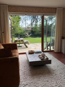 a living room with a couch and a coffee table at Huis De Mijmering in Heikant