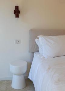a bedroom with a white bed and a clock on the wall at La Farmacia in Stresa