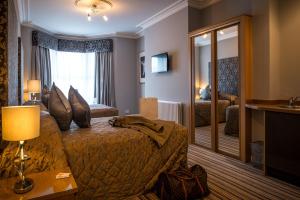 a hotel room with a bed and a mirror at York House Hotel in Whitley Bay