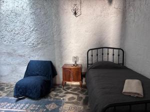 a bedroom with a bed and a chair at Casa Buena Vista in Ugíjar