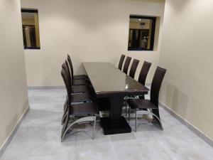 a dining room with a black table and black chairs at فندق اسفار الحجاز 2 in Al Masfalah