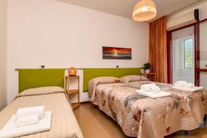 two beds in a room with green and white at Civic 55 in Toscolano Maderno