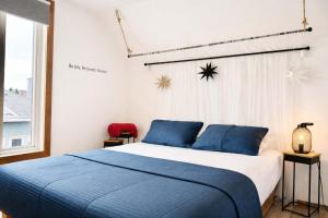 a bedroom with a blue and white bed and a window at Le Wolfe - 2 Bedrooms - 2 min Falls - Free Parking in Boischâtel