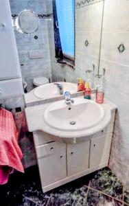 a bathroom with a white sink and a mirror at Magnolia Garden, 12 min walk to the beach in Ankaran