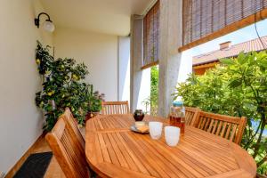 a wooden table with cups on top of a balcony at Civic 55 in Toscolano Maderno
