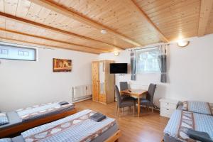 a room with two beds and a desk and a table at Knödelhof in Putzbrunn