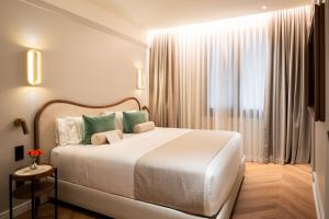 a bedroom with a large white bed and a window at Hotel Condal in Barcelona +60 photos