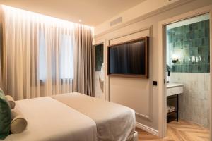 a hotel room with a bed and a television at Hotel Condal in Barcelona
